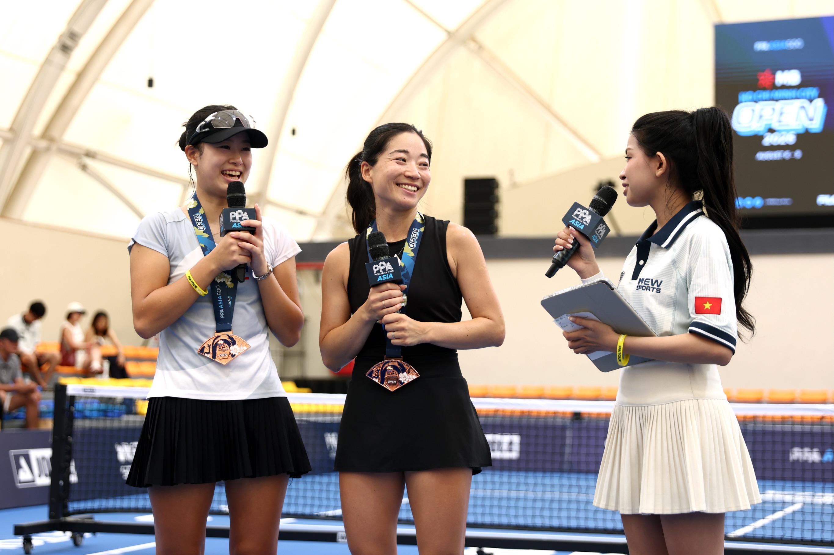 Aiko Yoshitomi and her doubles partner wearing bronze medals during a post-match interview in Ho Chi Minh City.