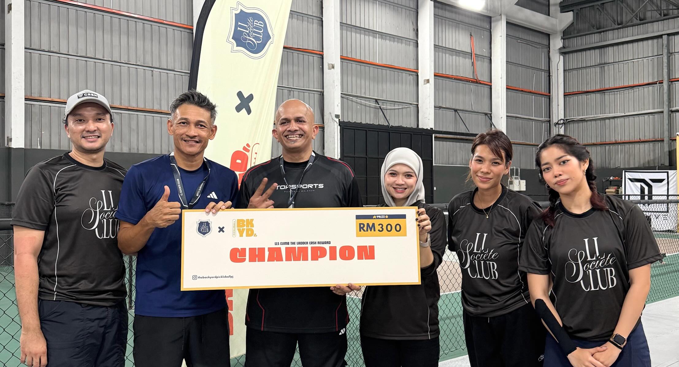 Champion team holding their RM300 prize check from The Backyard's Ladder Tournament number 2