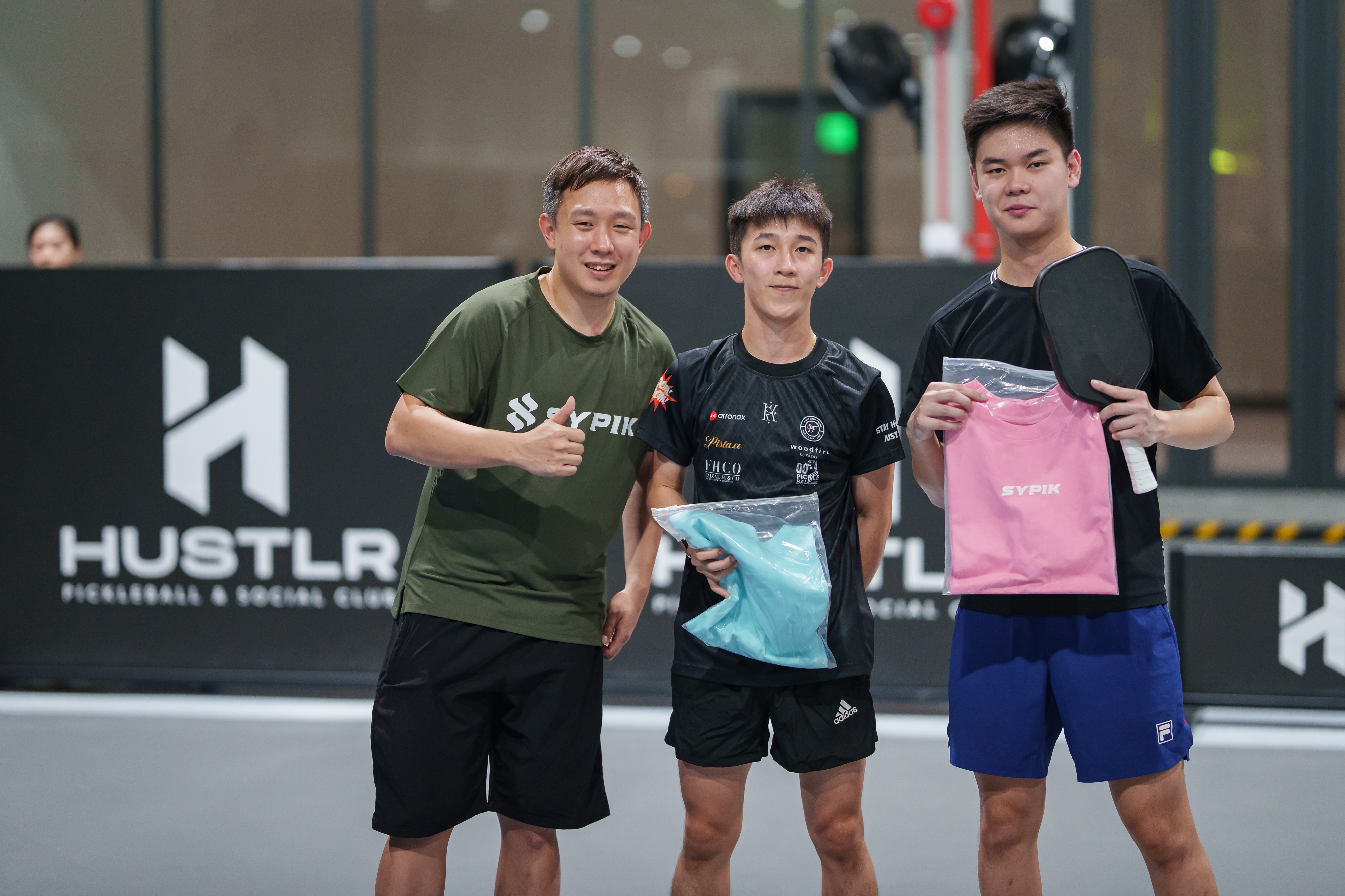 A Sypik pro player poses with fans holding merchandise at Hustlr