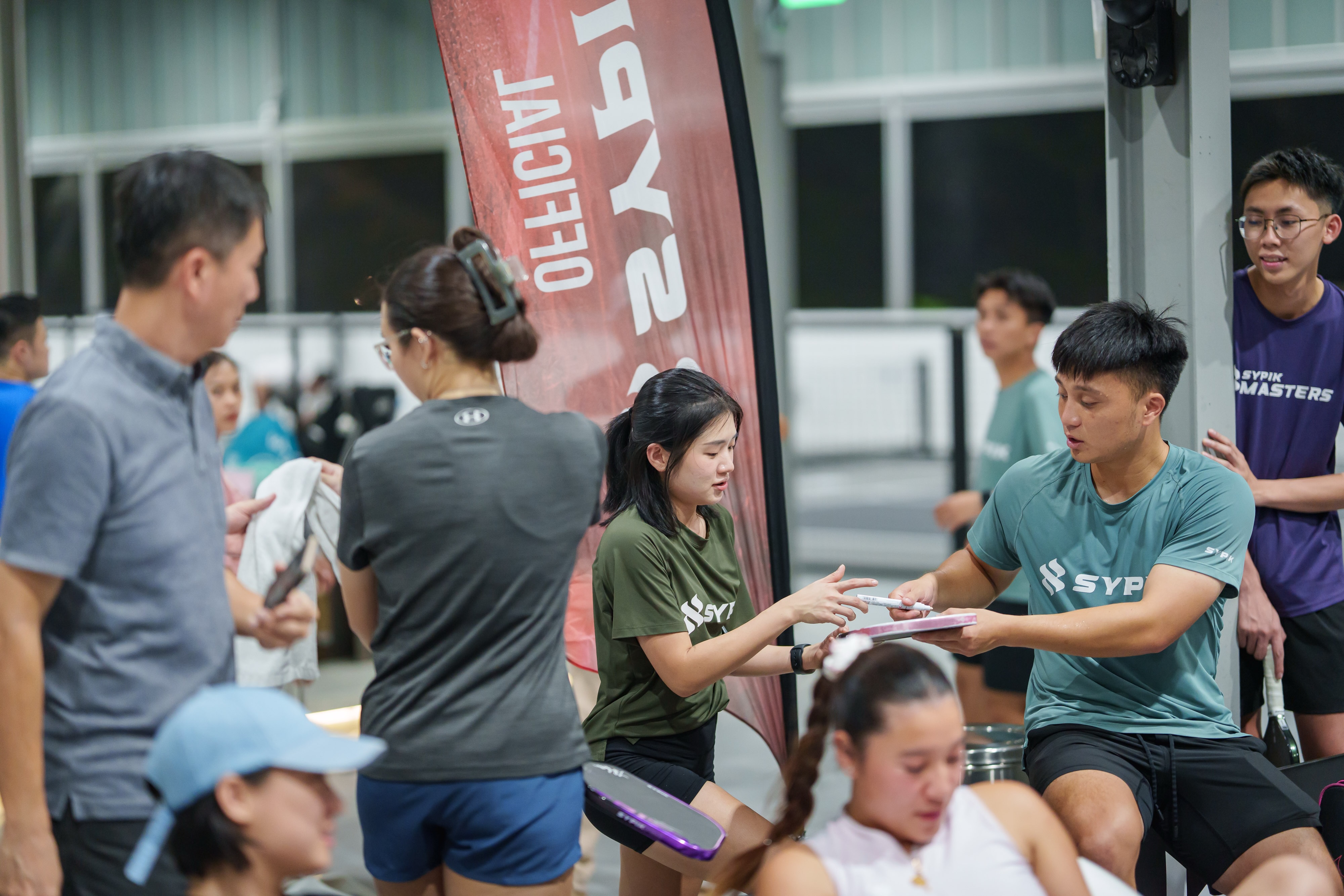 Sypik player signing an autograph for a community member at the social night