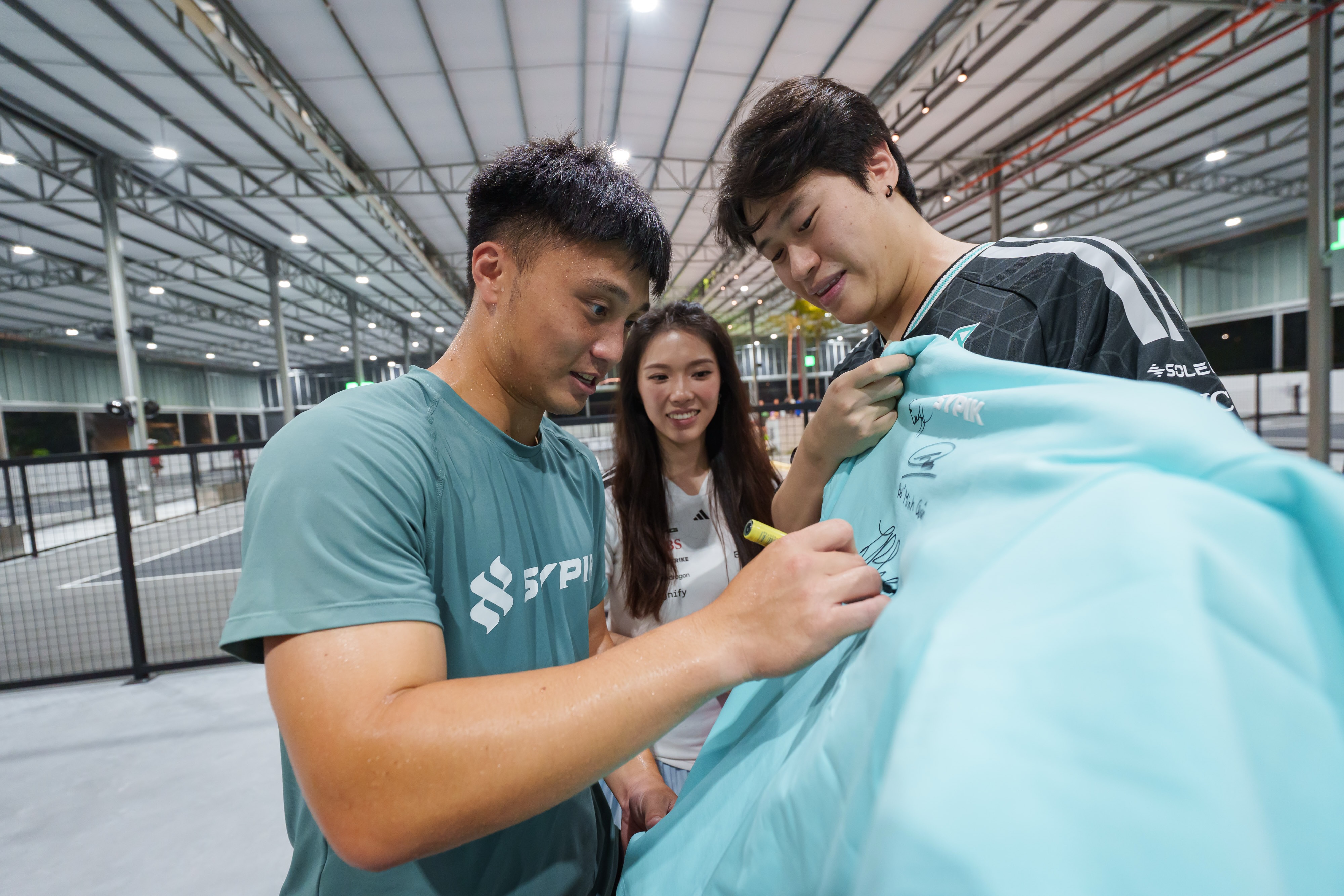 A Sypik pro player signing a fan's jersey up close at Hustlr