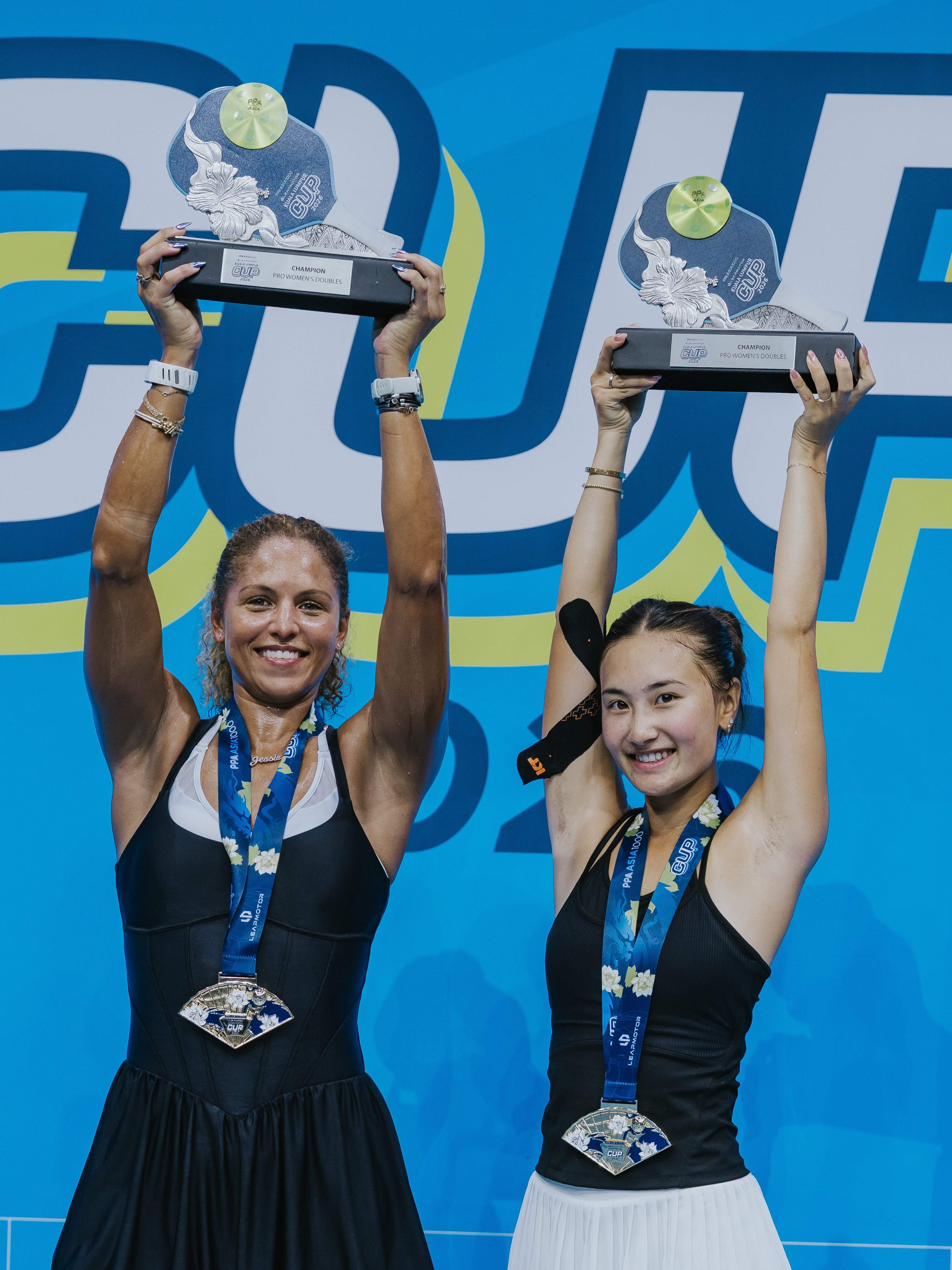 Alix Truong and Jessie Irvine hoist their Women's Doubles Champion trophies at the Leapmotor Kuala Lumpur Cup 2026