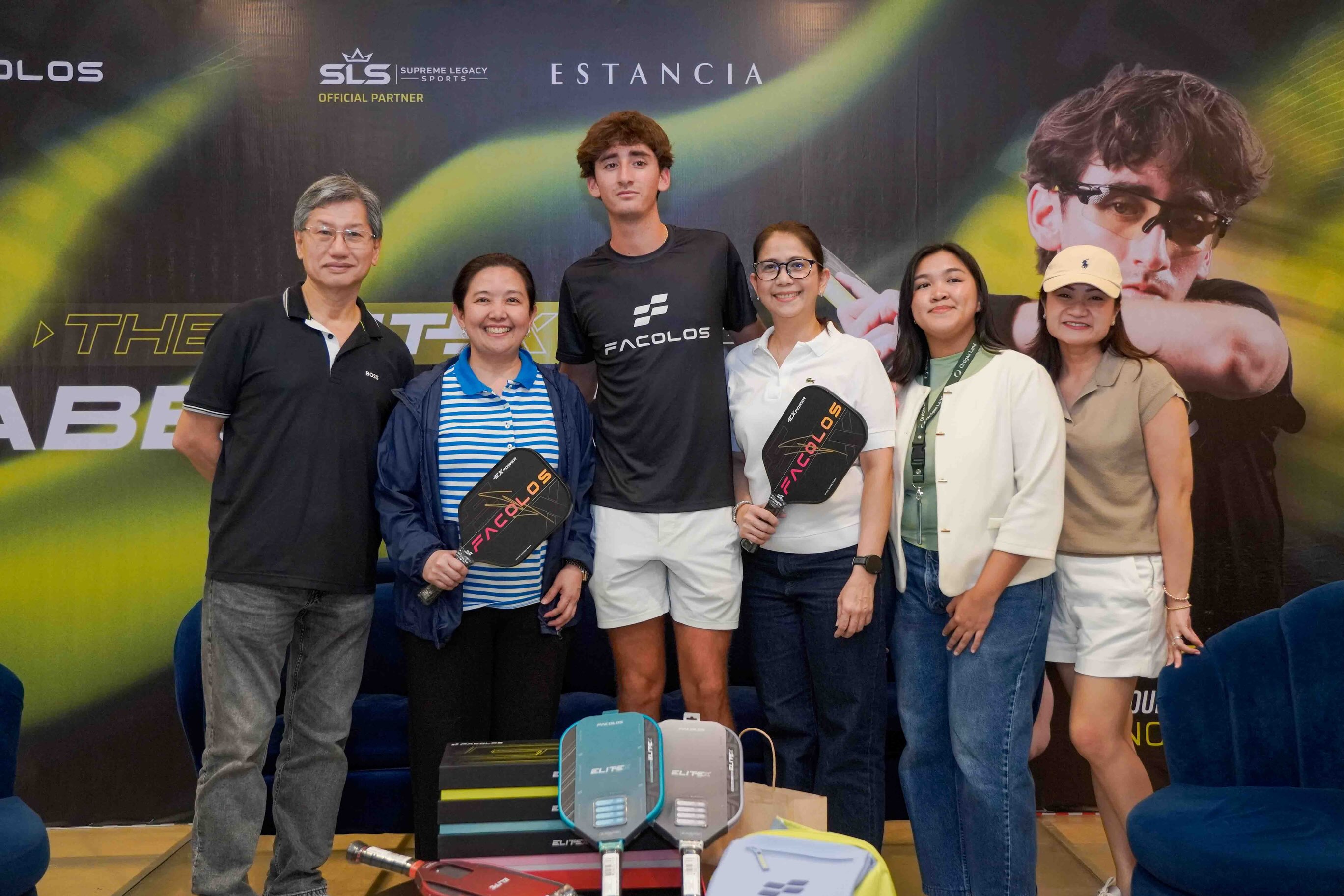 Gabe Tardio poses with Facolos and Ortigas Land guests, and two fans holding signed Facolos paddles, at Estancia