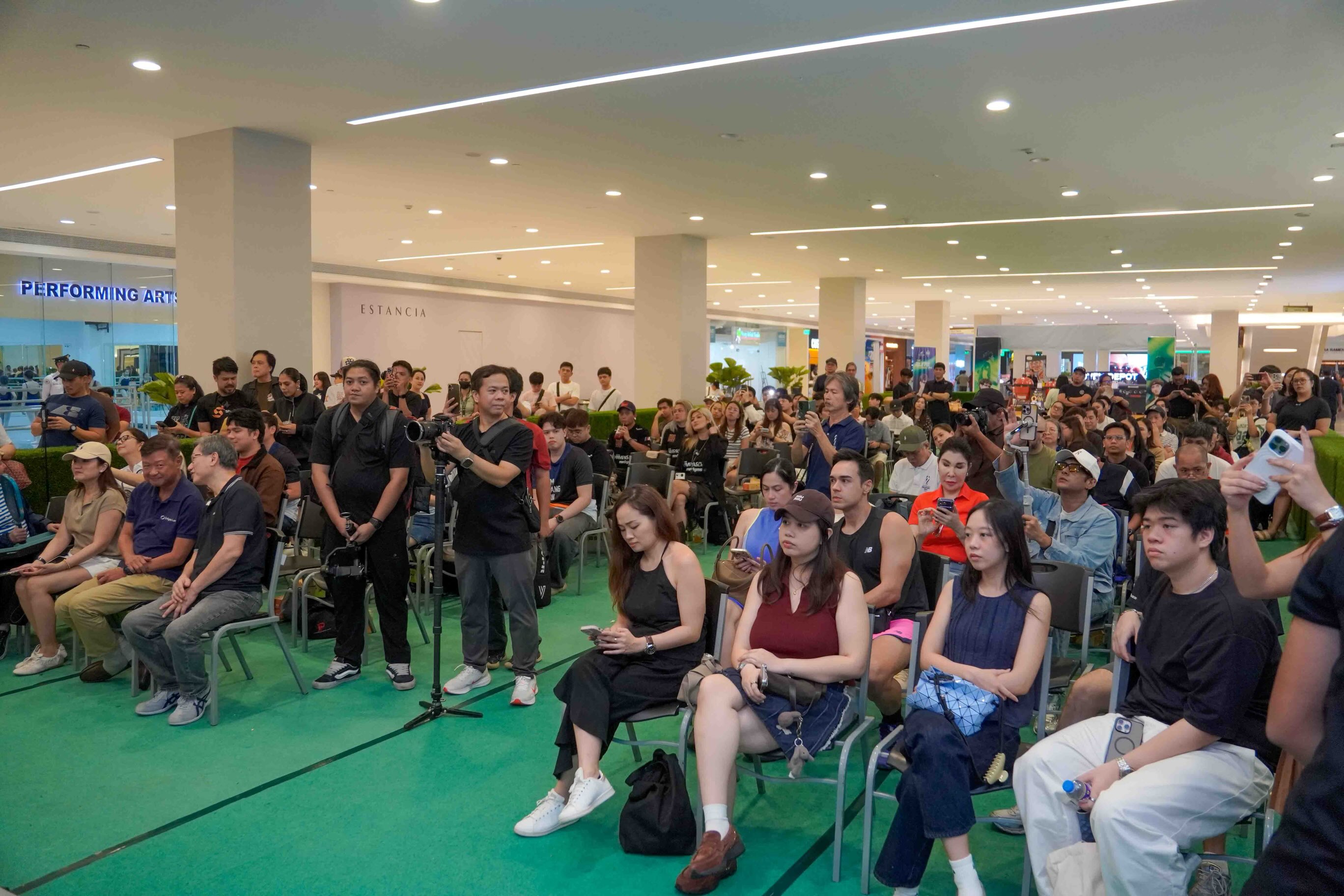 A large seated crowd fills the event space at Estancia mall for Gabe Tardio's Philippines stop