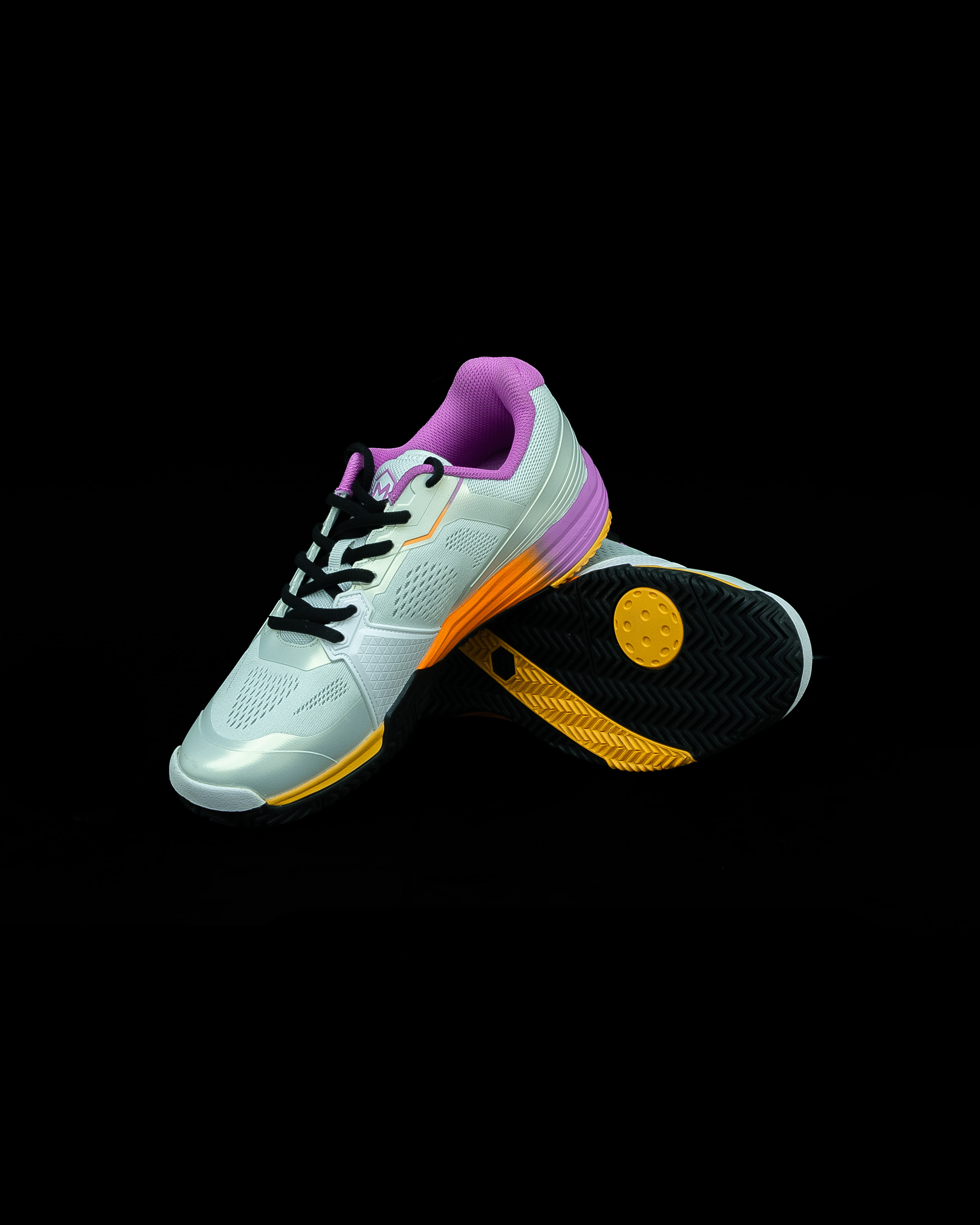 Pair of Friday x Montis Drop 1.0 Sunset shoes photographed on a black background, one showing the sole
