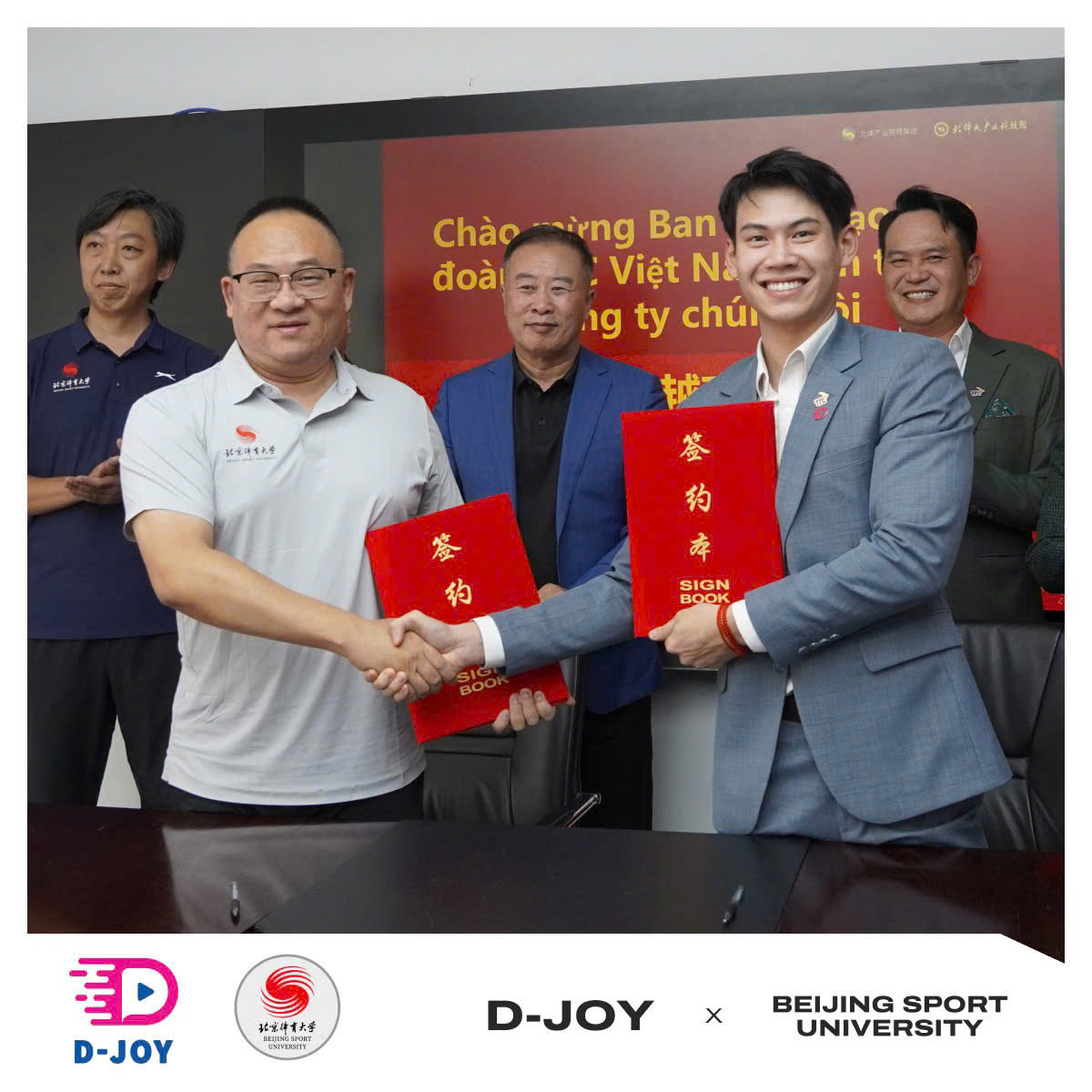 Dang Quang Anh, D-Joy chairman, shaking hands at the signing in Beijing with a Beijing Sport University representative.