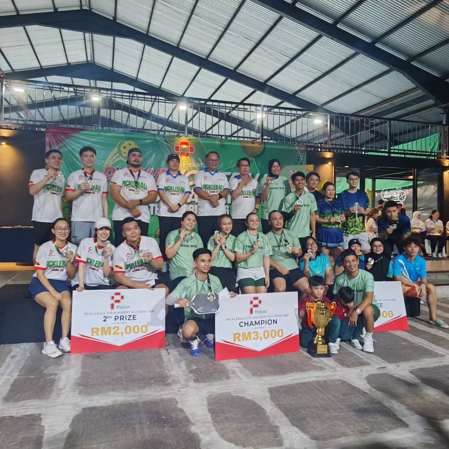 Group photo of all teams with the RM2,000 and RM3,000 prize boards
