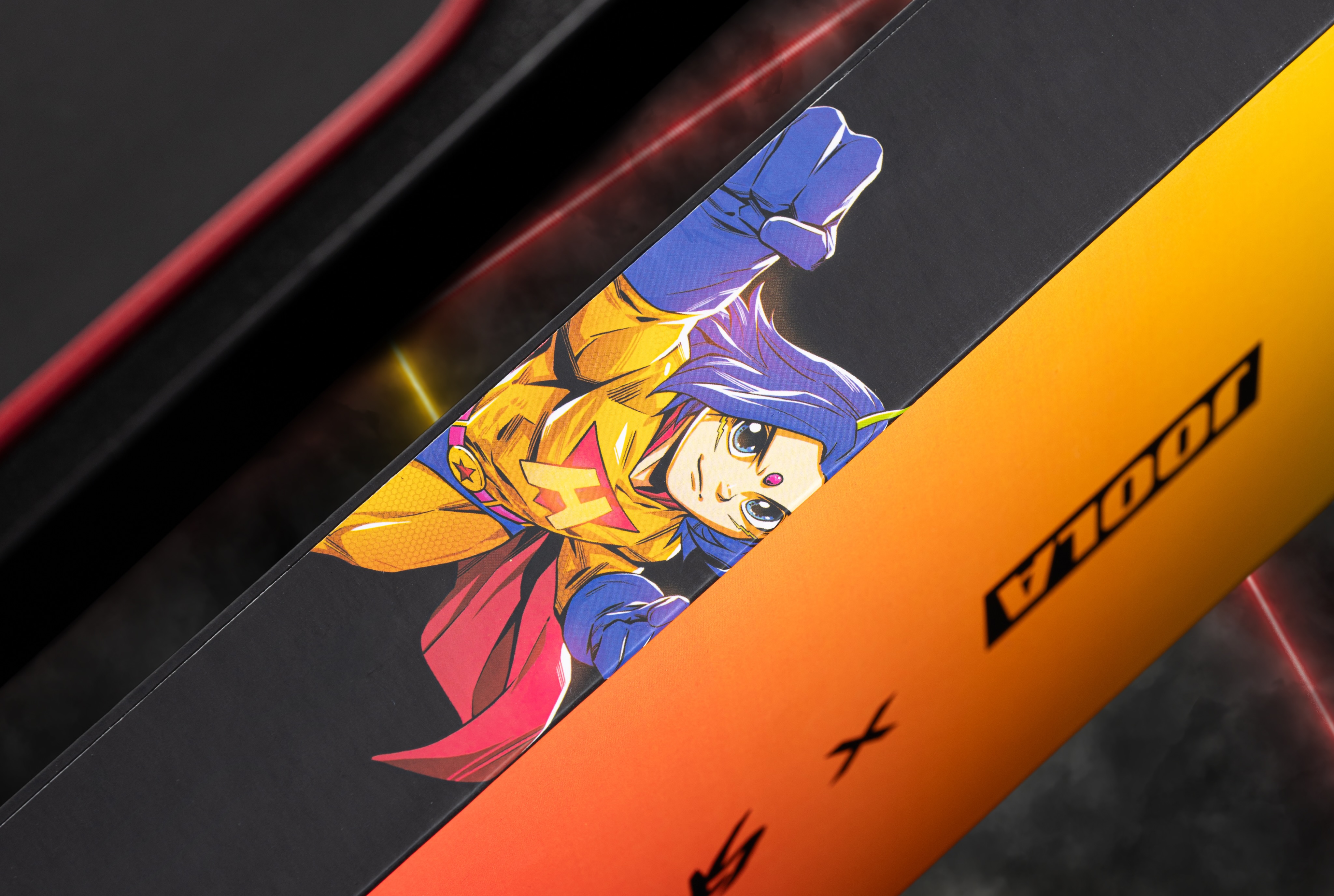 Close-up of illustrated caped character artwork on black and orange JOOLA packaging