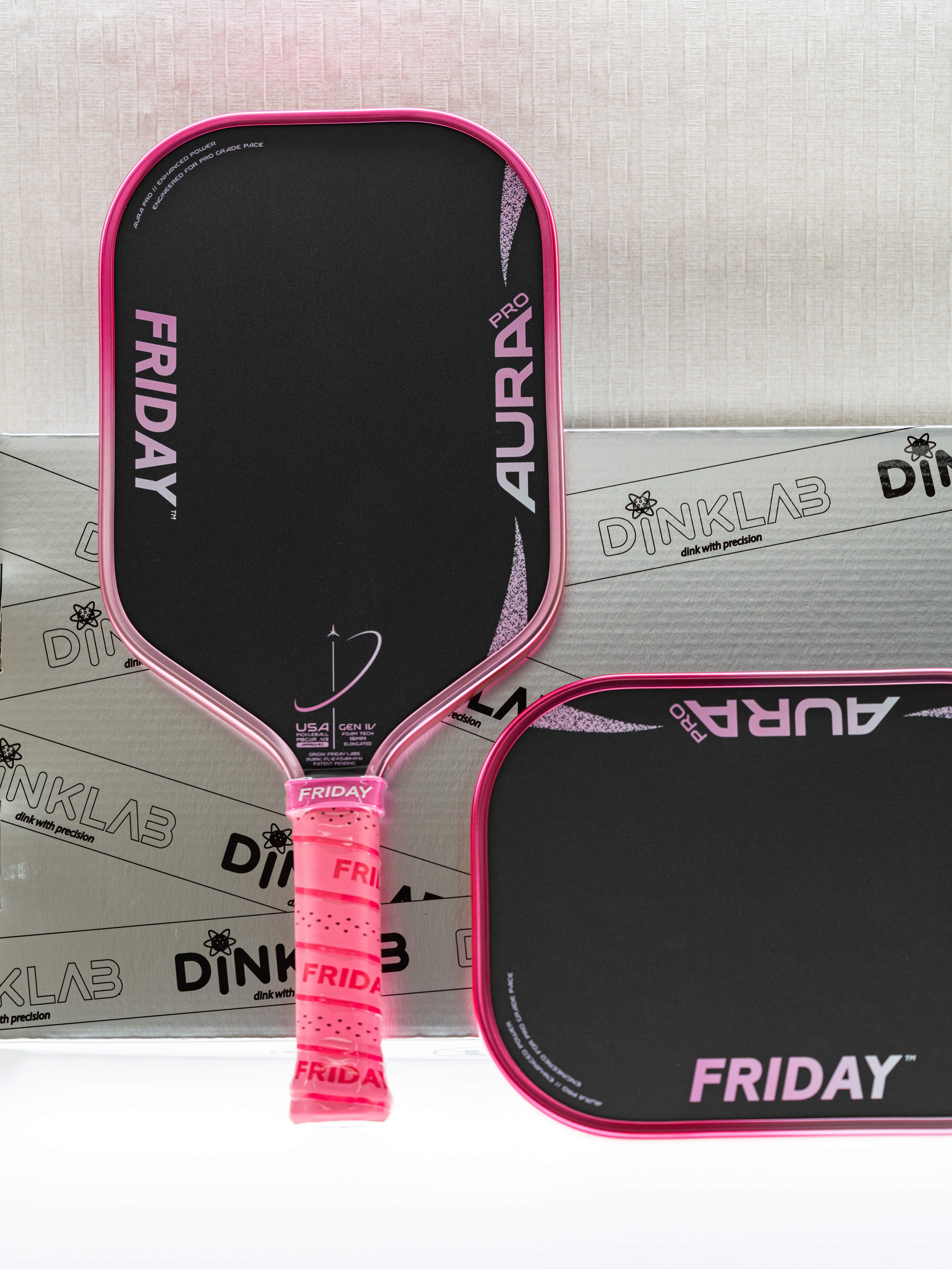 The Friday Aura Pro paddle leaning on a Dinklab-branded box.