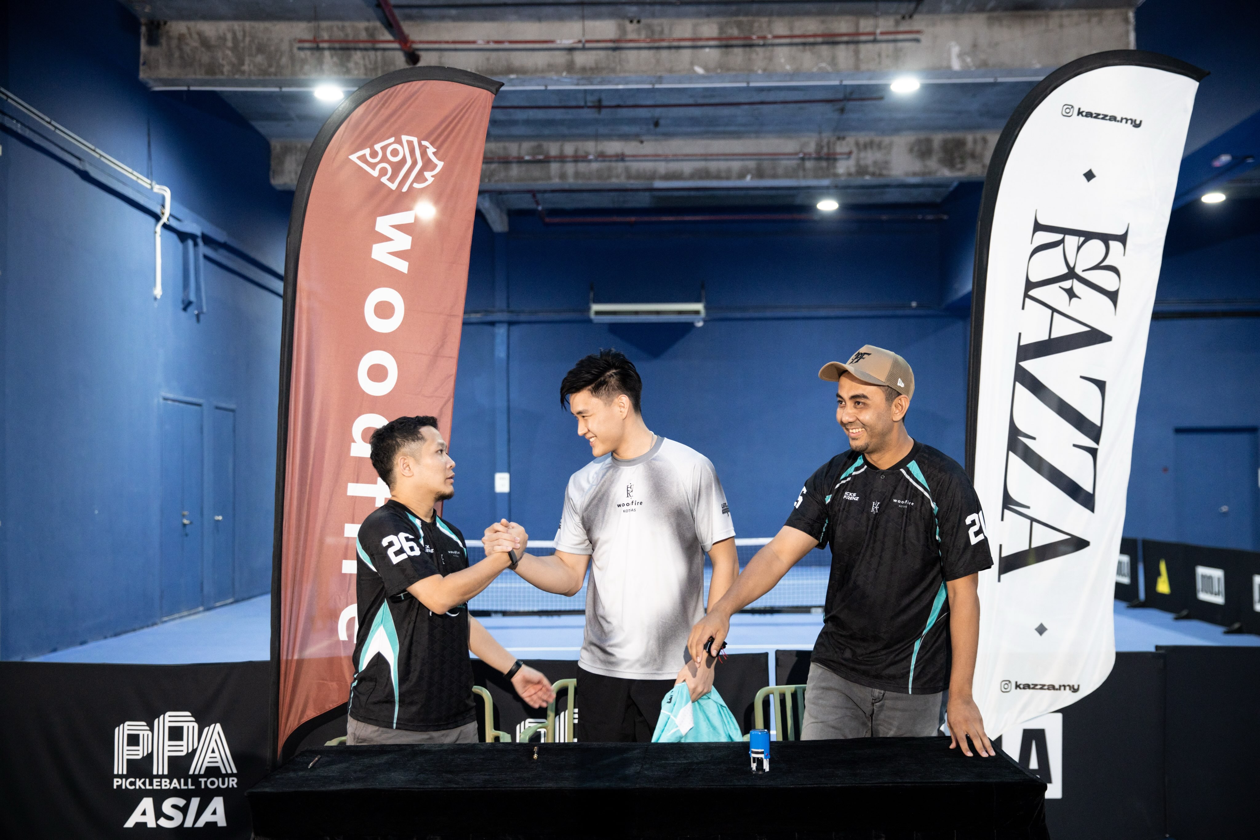 A handshake at the signing event between a man in a grey shirt and a man in a black jersey
