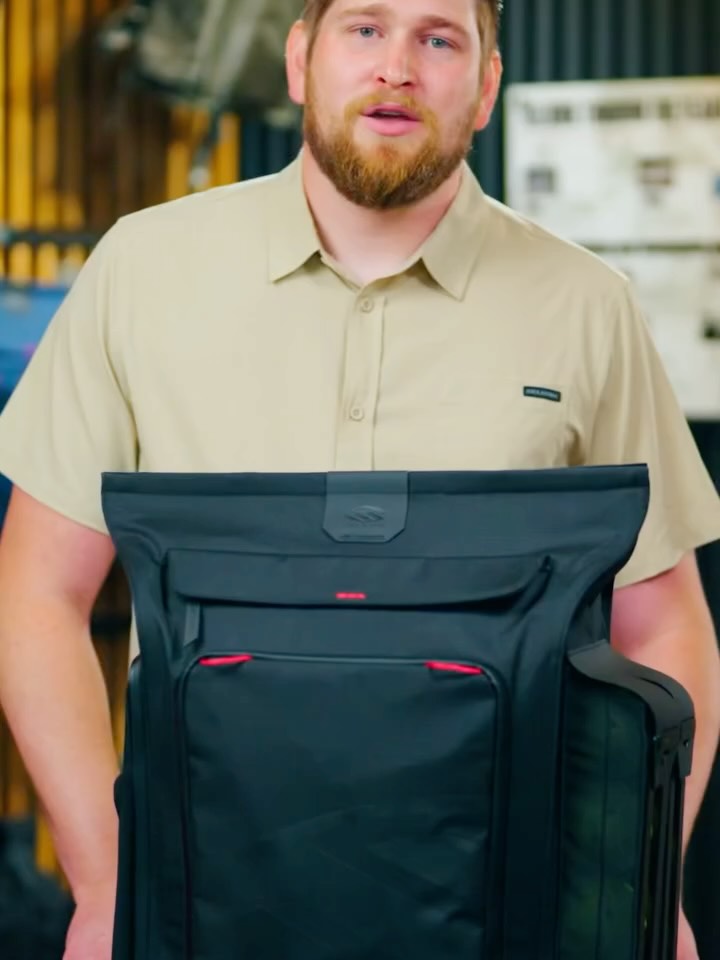 A presenter holding up a black backpack in a frame from the video in MyPickleball's post