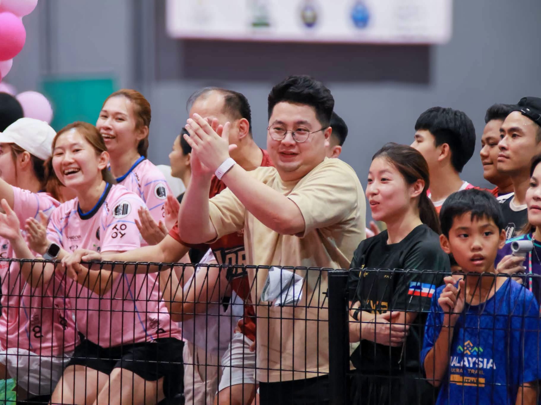Spectators cheer behind a fence at the Pink Ribbon Ladies Pickleball Tournament 2026 in Tawau