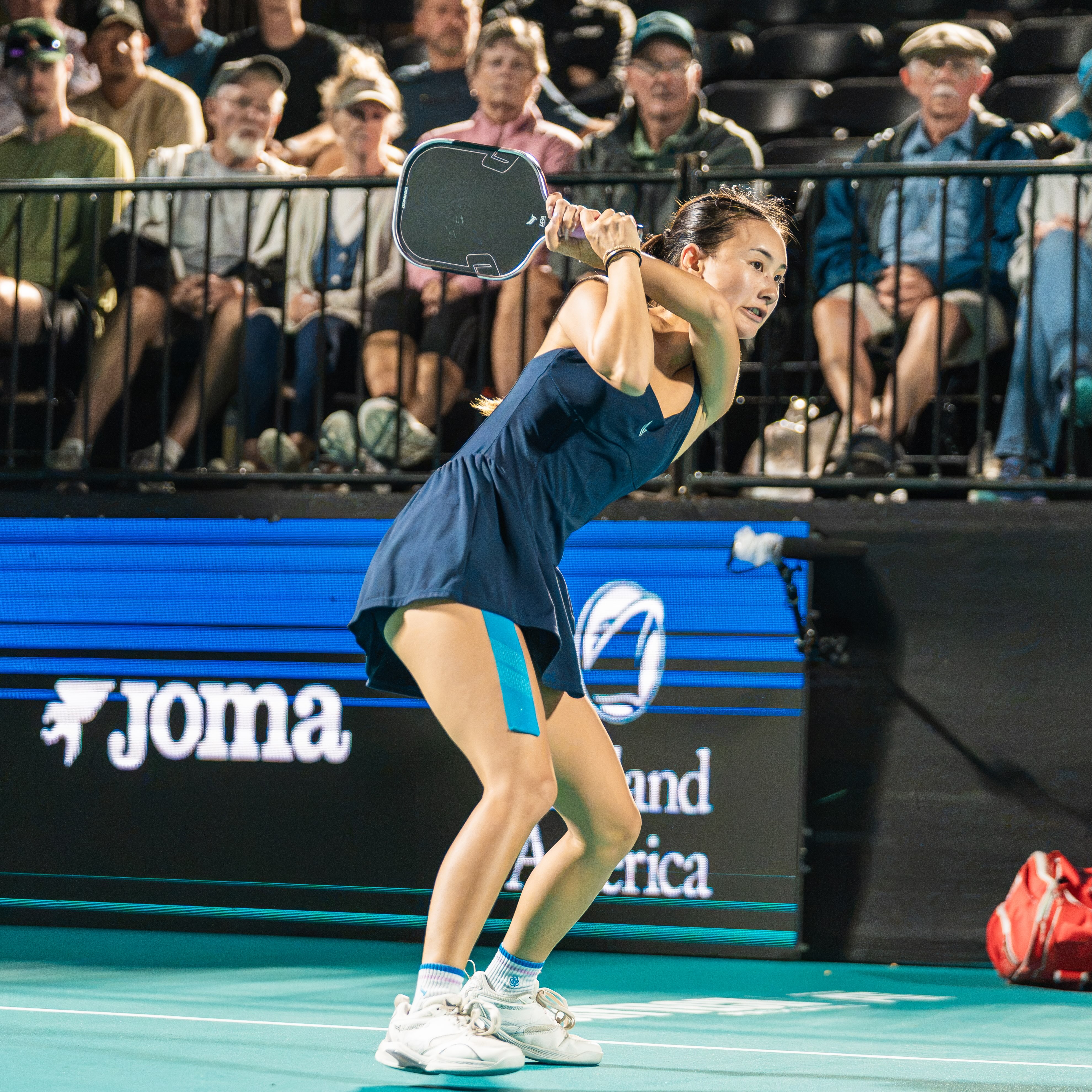 Alix Truong playing a backhand in front of sponsor boards in Virginia
