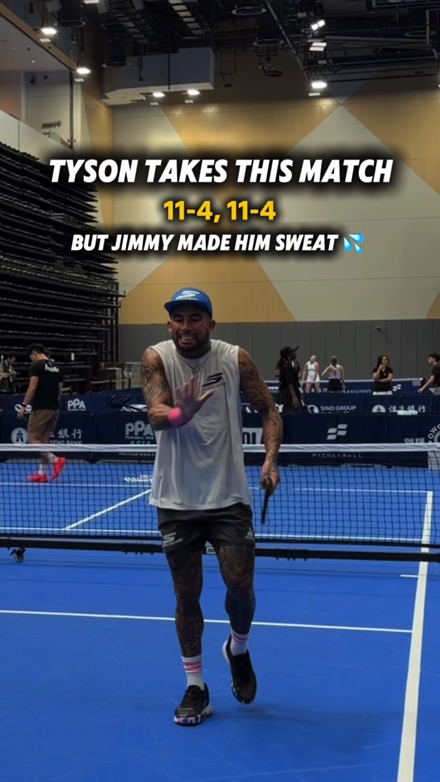 Tyson McGuffin in a blue cap waving to the camera on court after beating Jimmy Liong 11-4, 11-4
