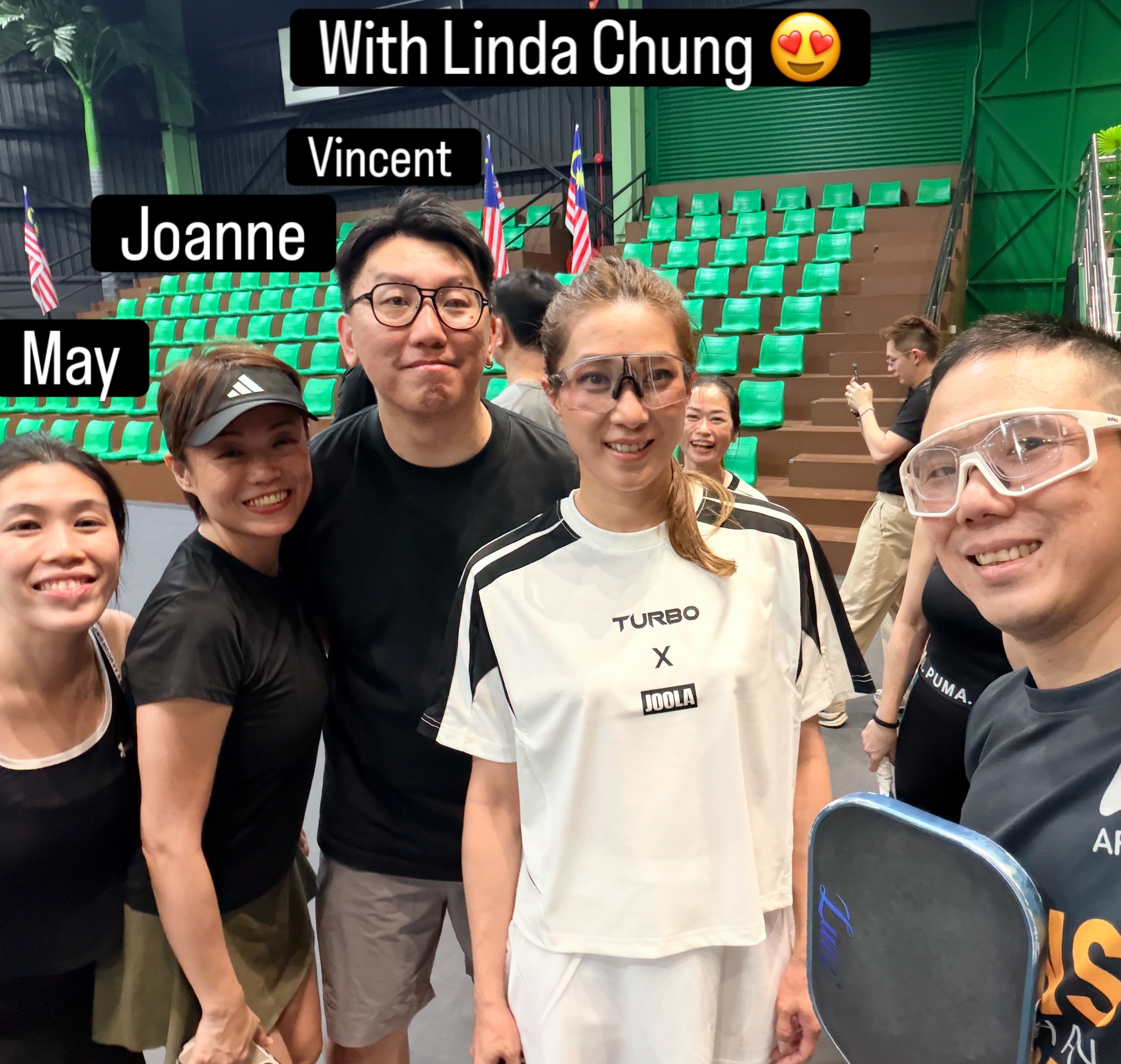 A group photo inside a pickleball arena with green seating, labelled With Linda Chung, Vincent, Joanne and May.
