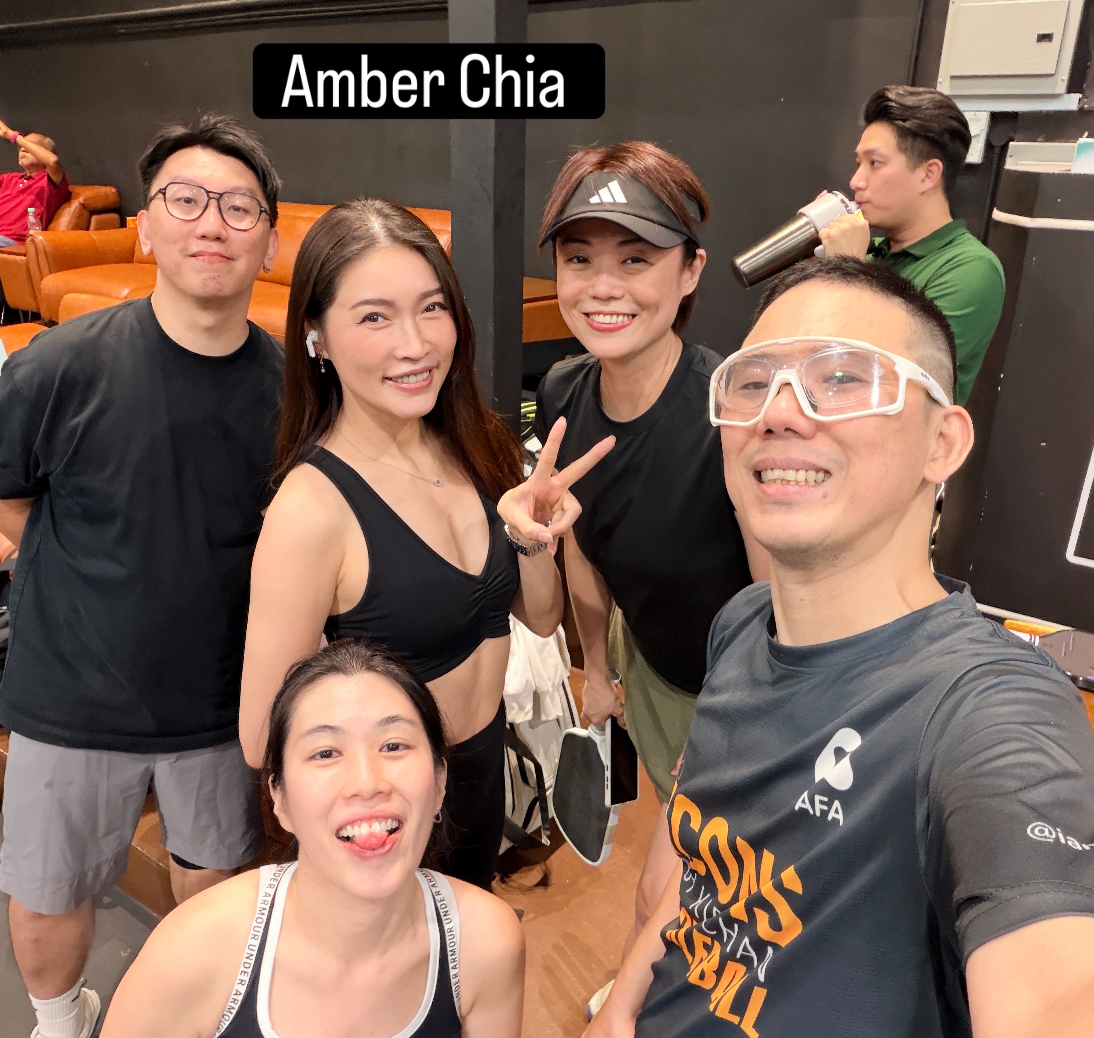 A group selfie of smiling people on leather sofas, with the slide label Amber Chia.